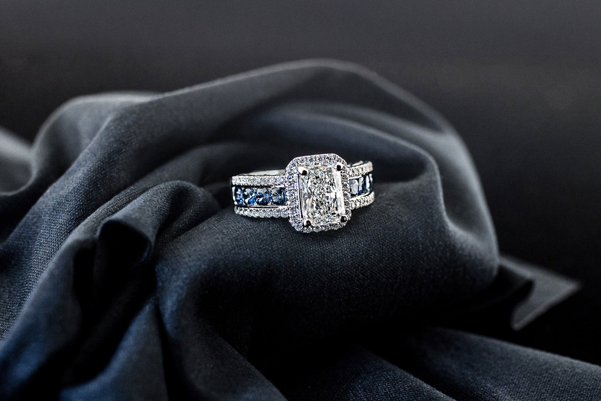 Radiant-cut lab-grown diamond engagement ring with diamond halo and sapphire band
