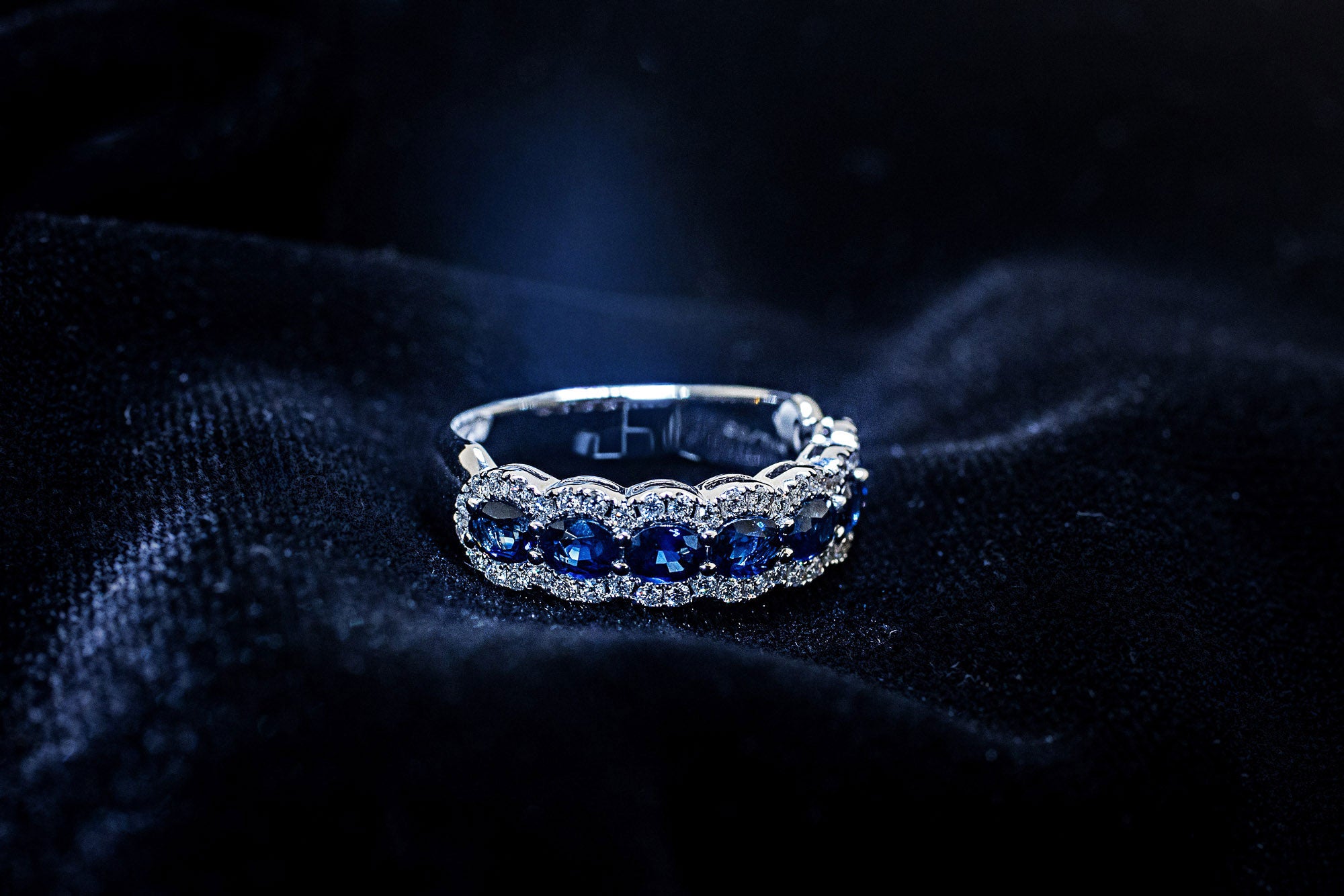 Oval blue sapphire band with diamond halos in 14K white gold