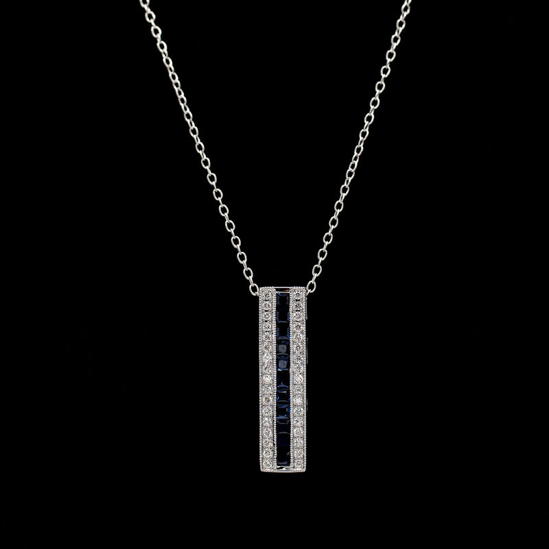 Vertical bar pendant in 14K white gold with a channel-set row of blue sapphires framed by two rows of diamonds — Gent Jay Jewelry Blue Line Collection
